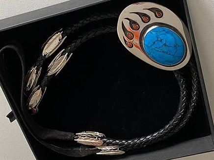 Bolo tie Giizisoniimii-bimisewin in jewelry box